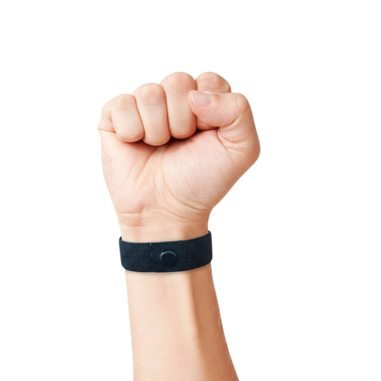 Hand wearing a black acupressure  wristband for stress relief on a white background