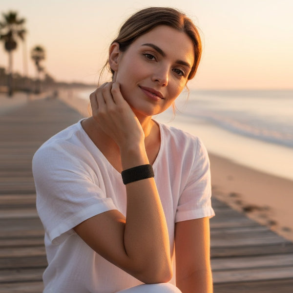 woman wearing an acupressure bracelet sitting on the boardwalk at the beach